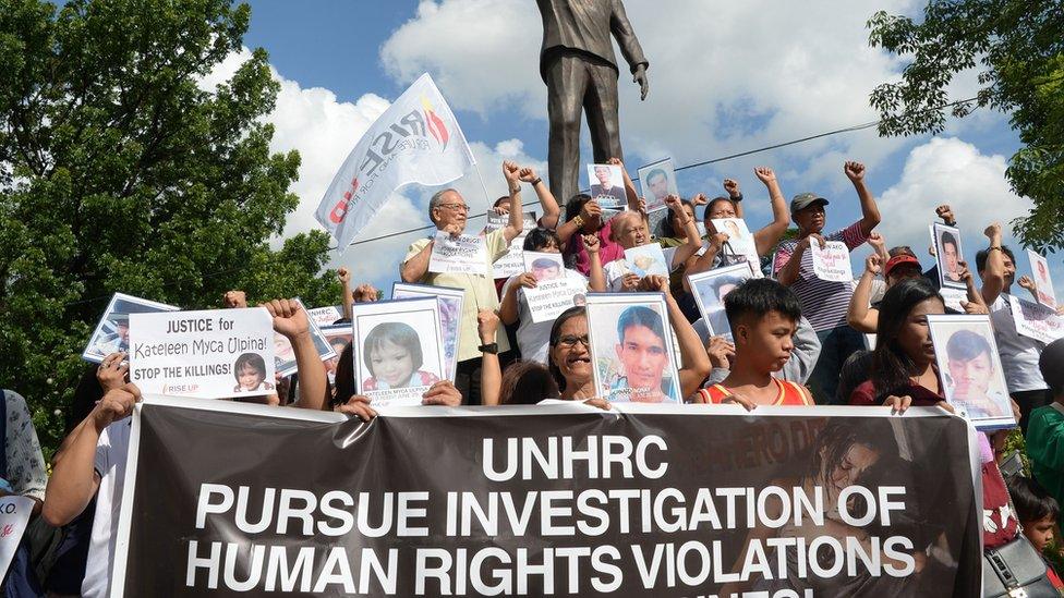 Relatives of victims of extrajudicial killings hold portraits of their relatives during a memorial mass at the Philippine Human Rights Commission on July 9, 2019