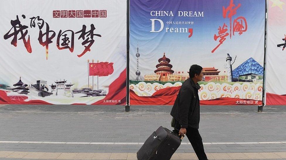 A man walking past 'The China Dream' posters