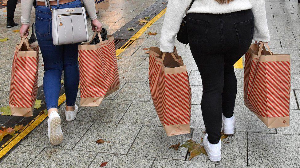 shoppers carrying bags on high street