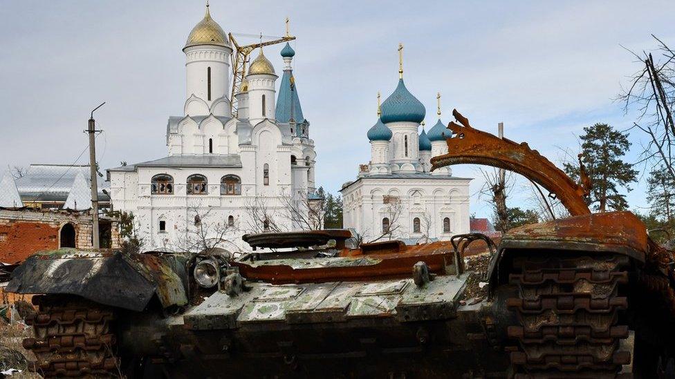 Destroyed Russian tank in front of orthodox temple in the liberated town of Sviatohirsk