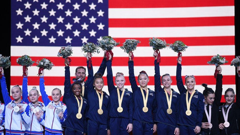 Simone-Biles-and-USA-team-winning-gold-medal-at-World-Championships