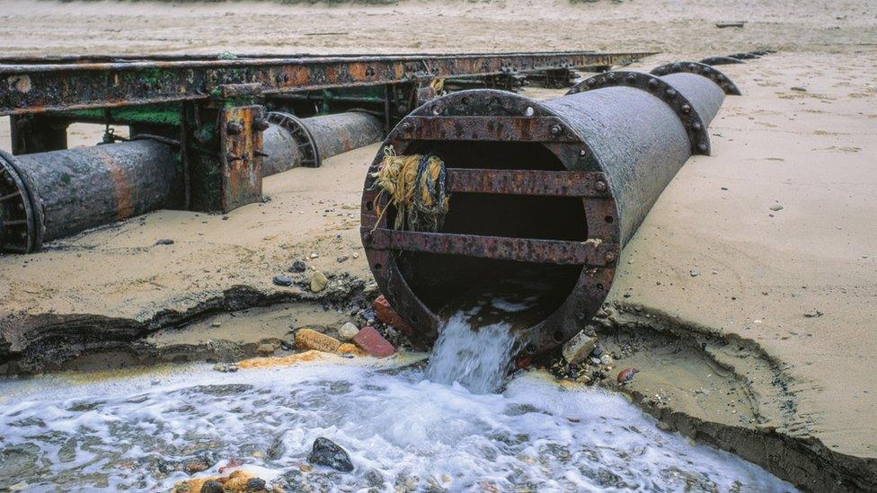 Waste water being released by a pipe onto a UK beach