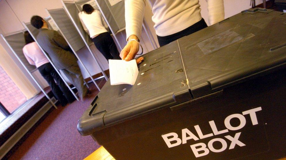 Woman placing a ballot paper in a ballot box