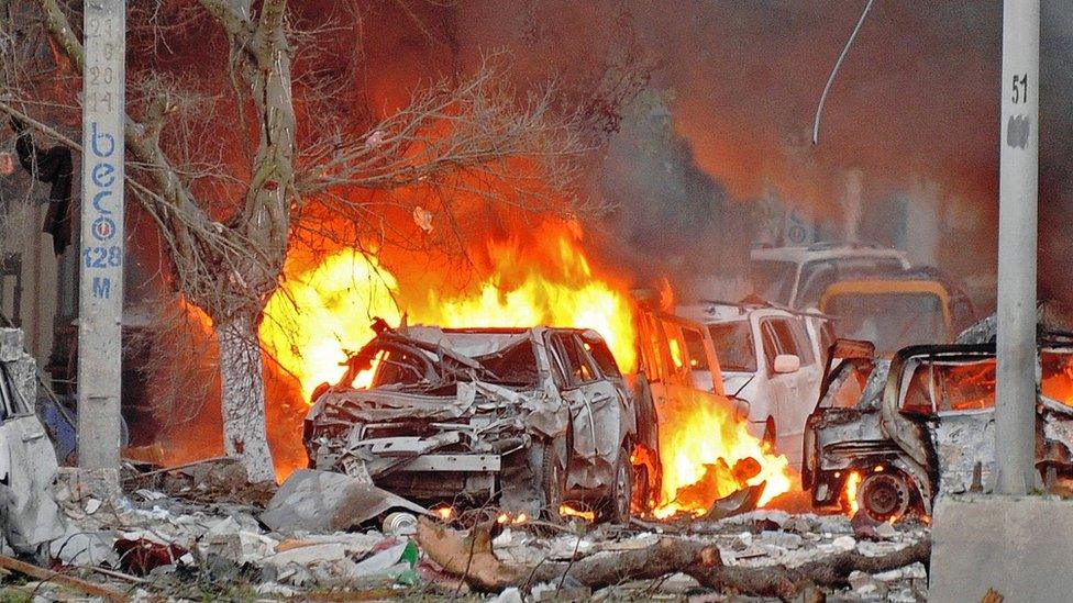 Wrecked cars burn at the scene of a terror attack in Mogadishu, June 2016