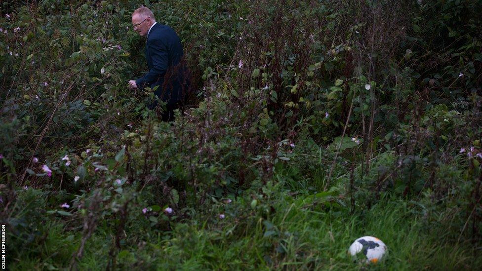 A club official trying to locate lost footballs outside Galabank