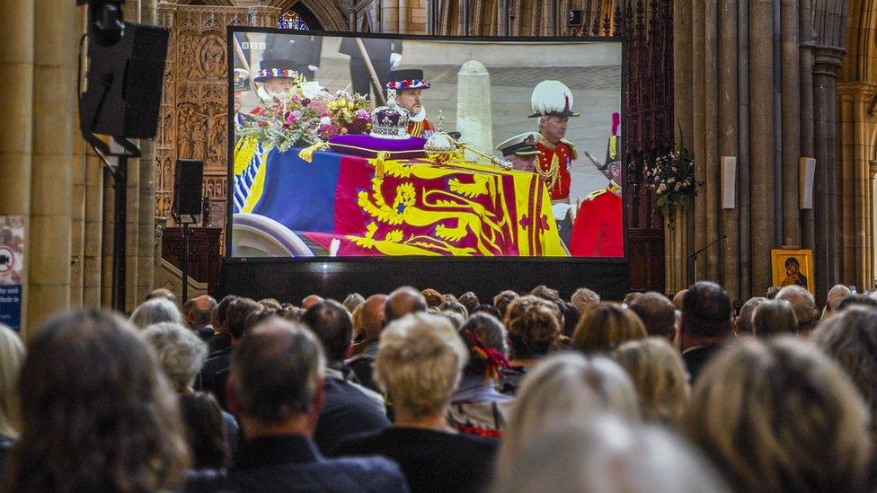 Members of the public gather to watch large screen live BBC TV coverage of the funeral of Queen Elizabeth II at Truro Cathedral