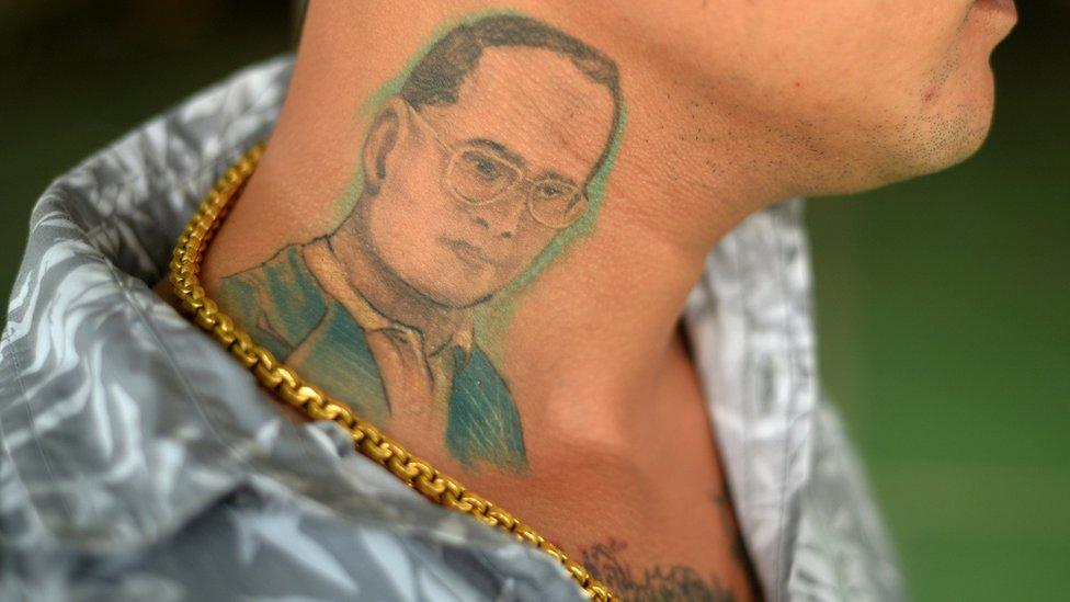 A man poses for a photograph to show his tattoo of Thailand's King Bhumibol Adulyadej in Phuket, Thailand, June 7, 2016.