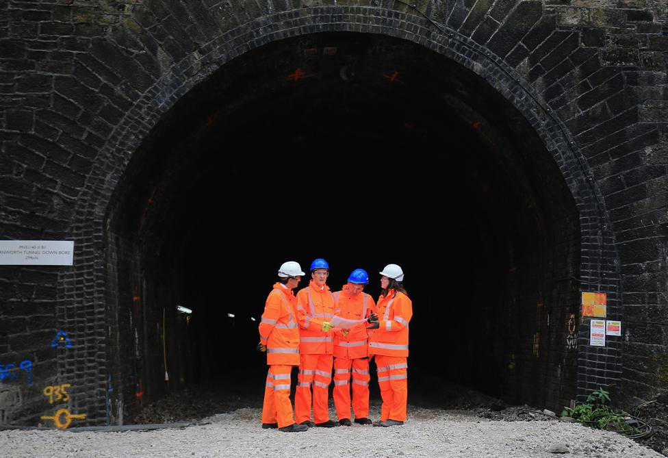 Chancellor of the Exchequer George Osborne (2L) and Commercial secretary Jim O'Neill (2R) chat to workers during a visit to Farnworth Tunnel electrification works on May 14, 2015 in Bolton, England