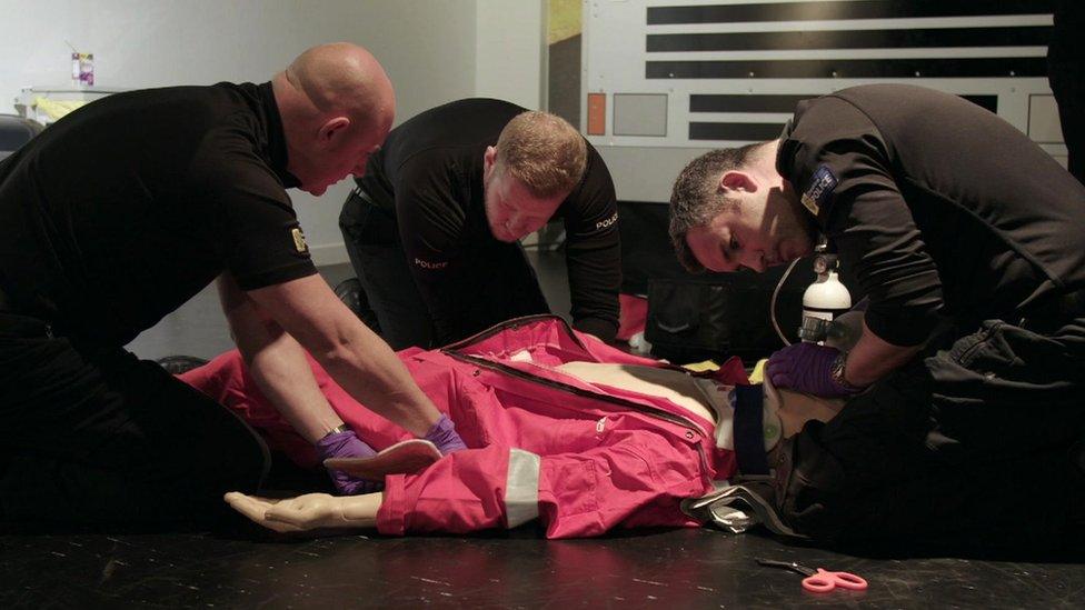 Officers training in emergency life-saving medicine