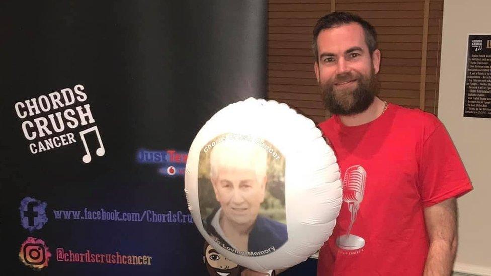 Mark Fielden holding a balloon with a picture of his late mum