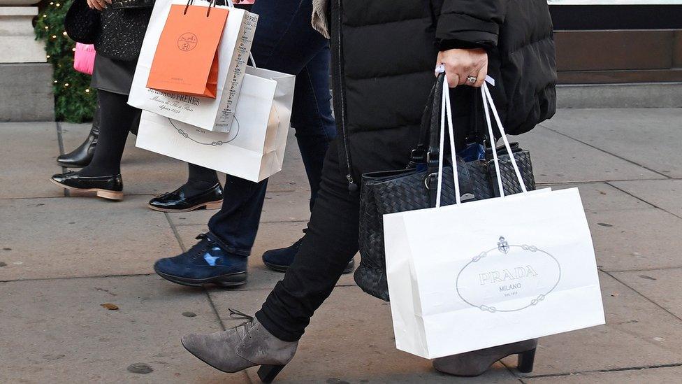 People walking down the street with shopping bags