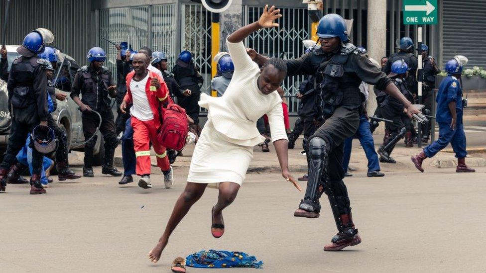 An anti-riot police man in Zimbabwe tackles a woman with his boot as they dispersed a crowd gathered to hear an address by leader of the MDC (Movement for Democratic Change) Alliance, Nelson Chamisa at Morgan Tsvangirai House, the party headquarters, in Harare, on November 20, 2019