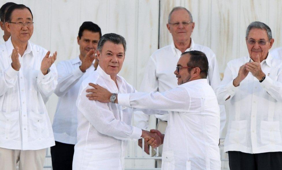 Colombian President Juan Manuel Santos (left and centre) and the head of the FARC guerrillas Timoleon Jimenez, aka Timochenko, shake hands during the signing of the historic peace agreement between the Colombian government and the FARC in Cartagena, Colombia, on September 26, 2016.