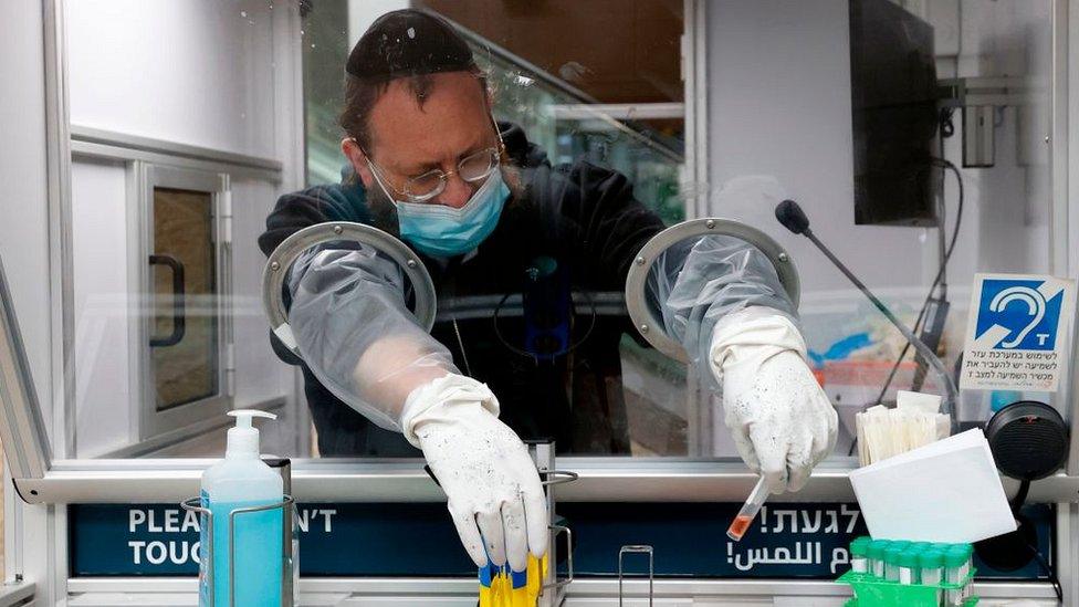 Israeli medic in PPE collecting test samples