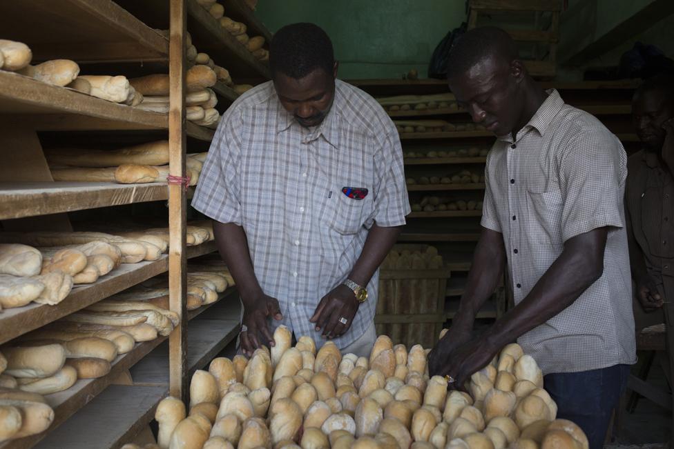 Mohammed Maiga (right) prepares loaves of bread to be placed on a delivery bike at Guemou Coura Bakery on 2 February 2019.