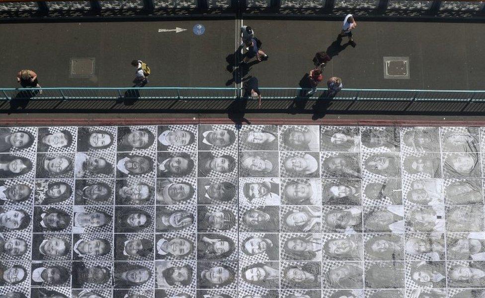 The faces of more than 1,000 Londoners pasted along the road at Tower Bridge