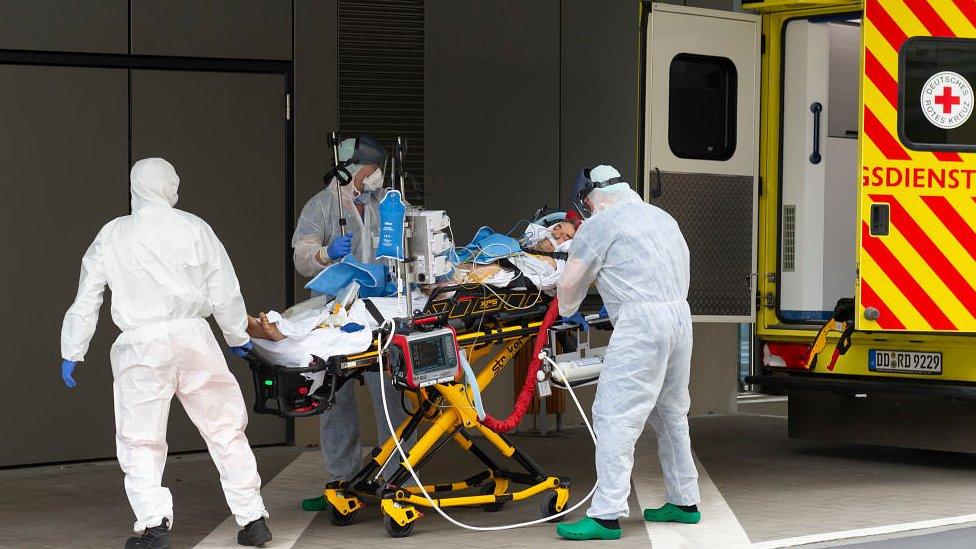 Staff are seen with a patient from Italy at the Corona Outpatient Clinic in the Dresden University Hospital on March 26, 2020 in Dresden, Germany