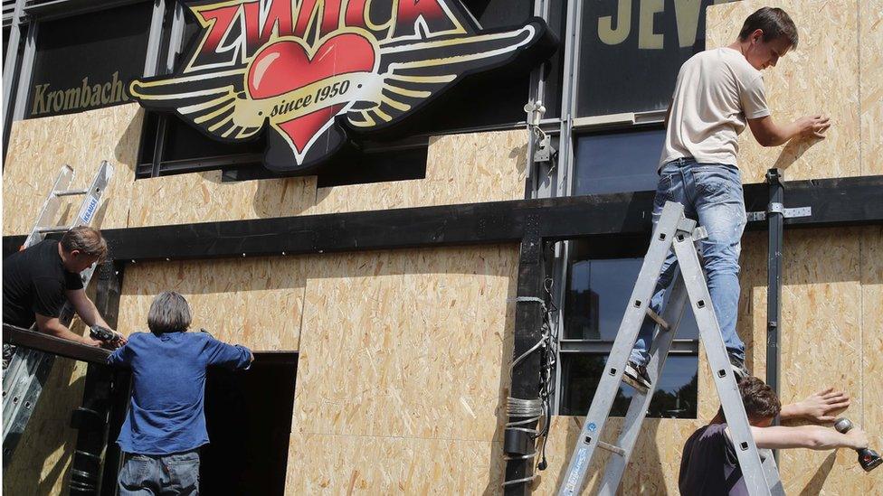 Workers place panels as a protection in front of pub windows near the venue of the G20 summit in Hamburg, Germany, July 6, 2017.