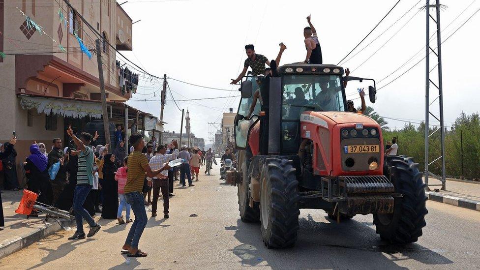 Palestinians drive an Israeli tractor that was seized after crossing the border fence with Israel from Khan Yunis in the southern Gaza Strip on October 7, 2023.