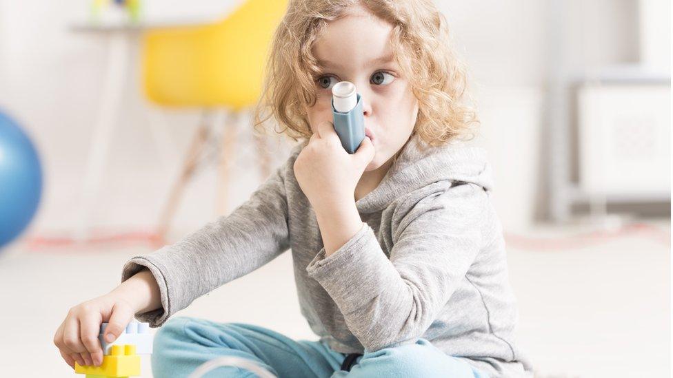 Girl using asthma inhaler