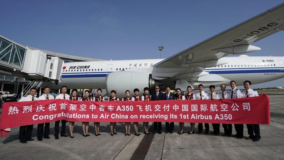 Air China staff standing in front of a new Airbus plane