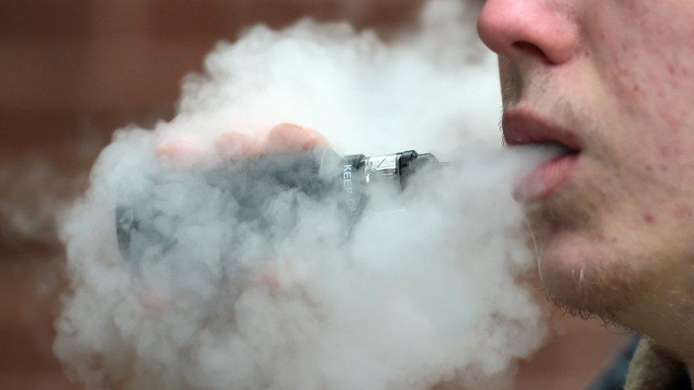 A young man vaping in the street