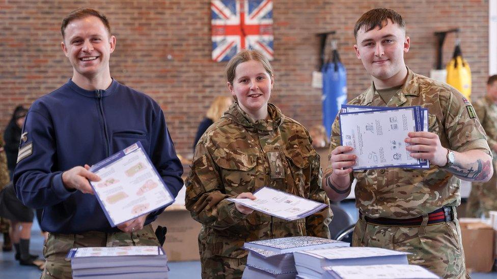 Soldiers helping to pack boxes