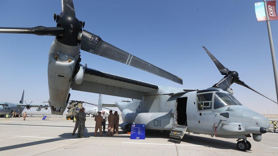 US servicemen under the wing of a tilt-rotor Bell Boeing V-22 Osprey at the Dubai Airshow on 8 Nov, 2015