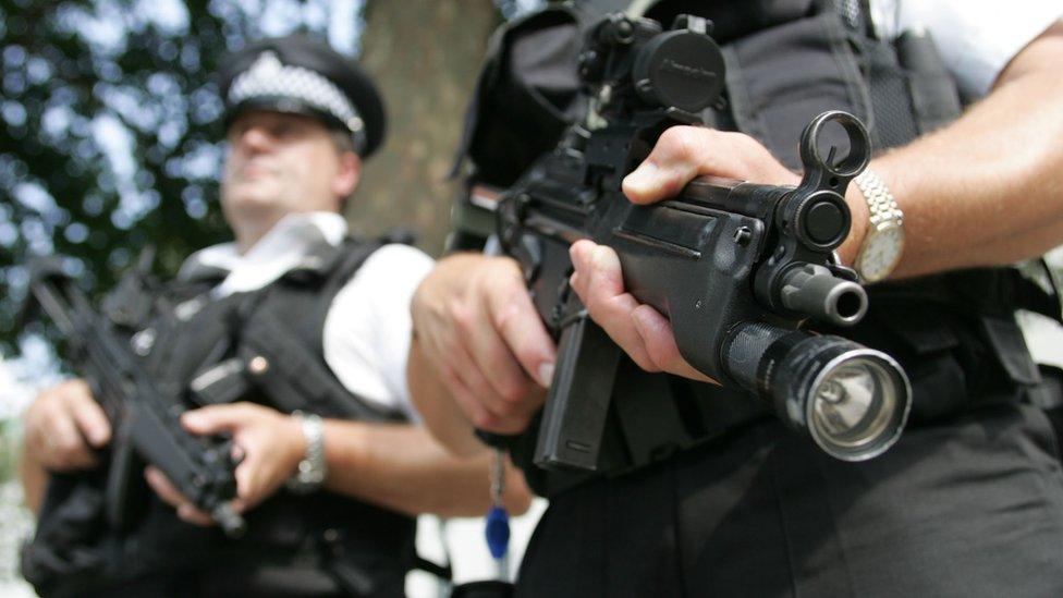 Two armed police officers patrol the streets around Whitehall, central London