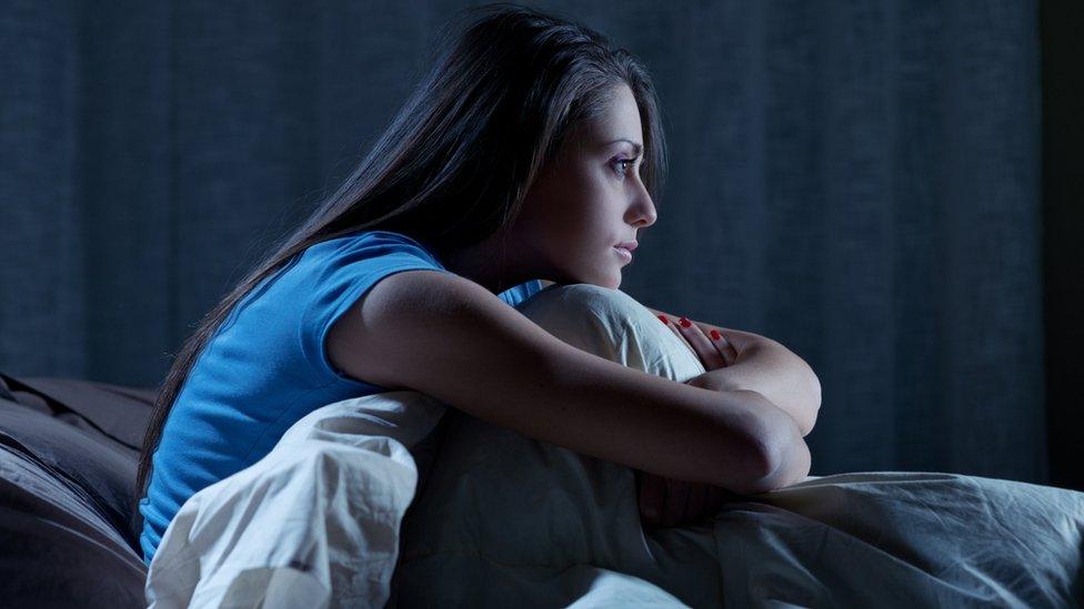 woman sitting up in bed