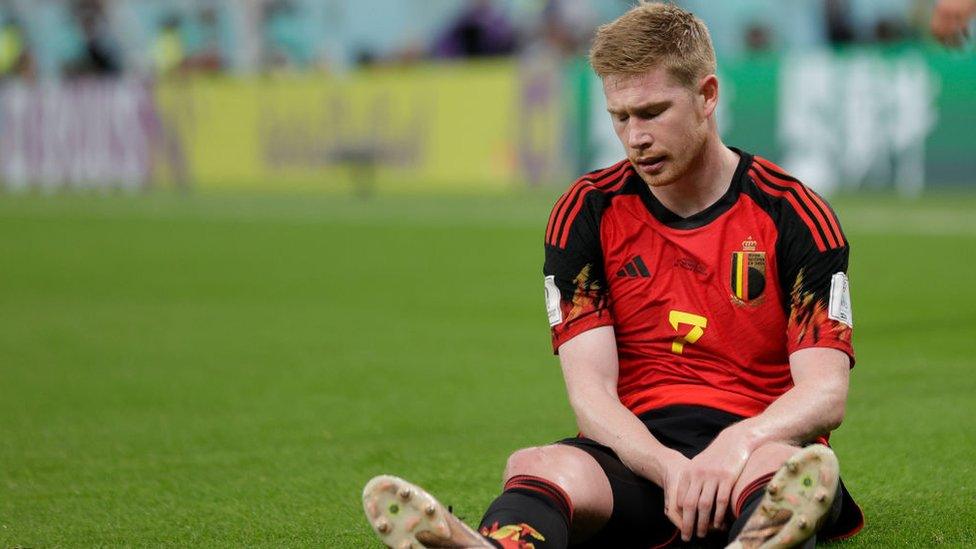 Kevin De Bruyne looking disappointed sitting on the pitch looking down after Belgium lost to Morocco