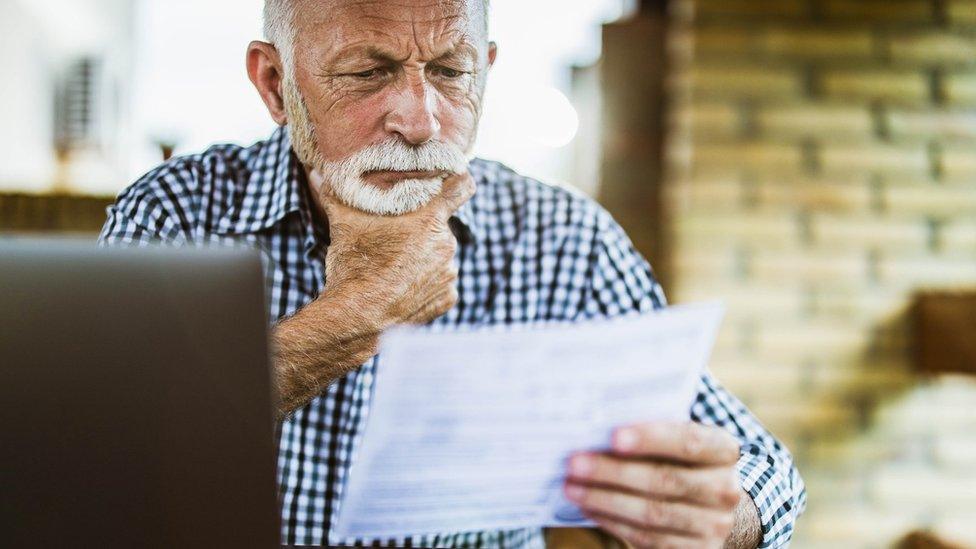 A man looks through financial paperwork