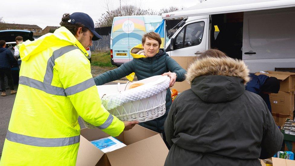 Volunteers load donations into a van in a carpark in Northampton.