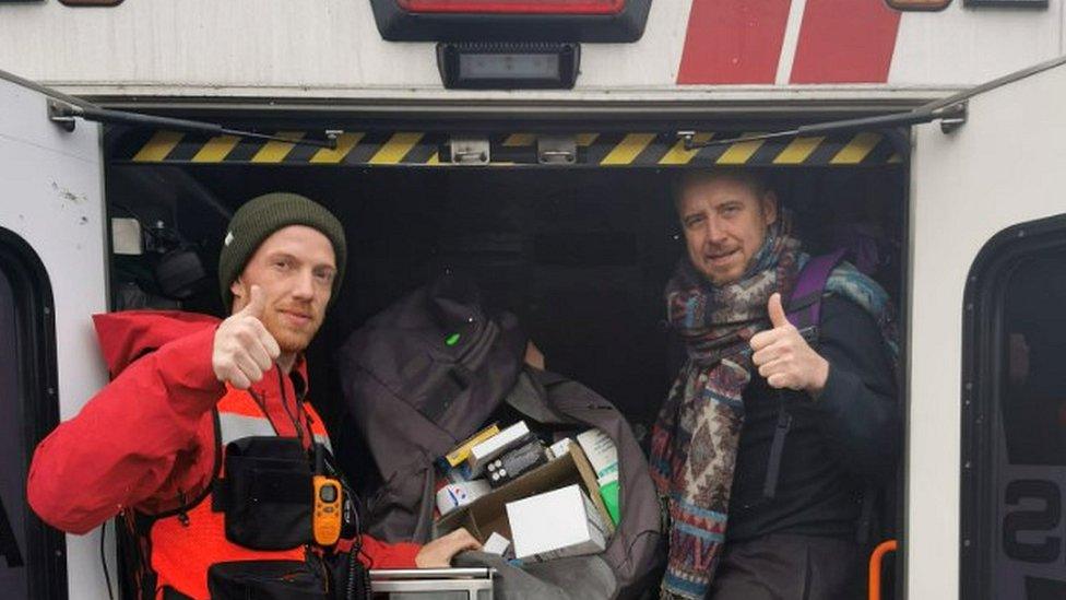 Paramedic and volunteer showing donations in ambulance