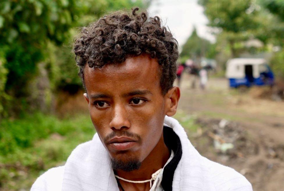  Fikre Tilahun, with a white top, stares