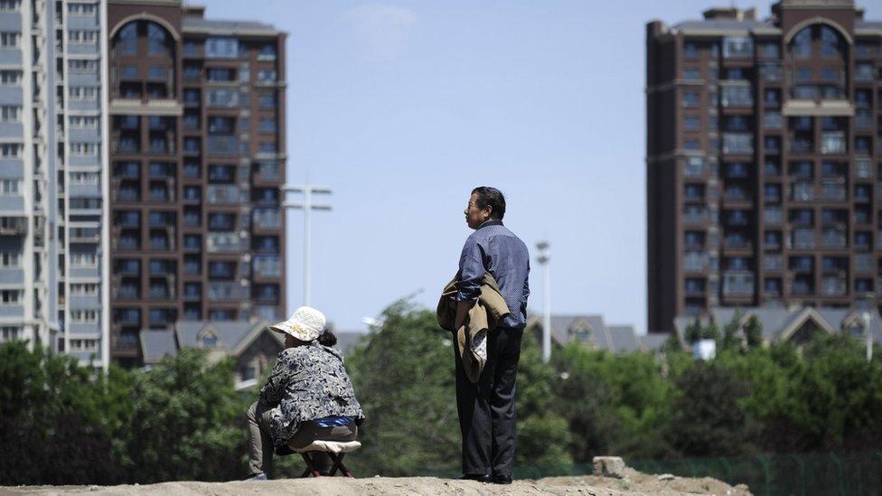 A man and a woman outside a construction site in Beijing