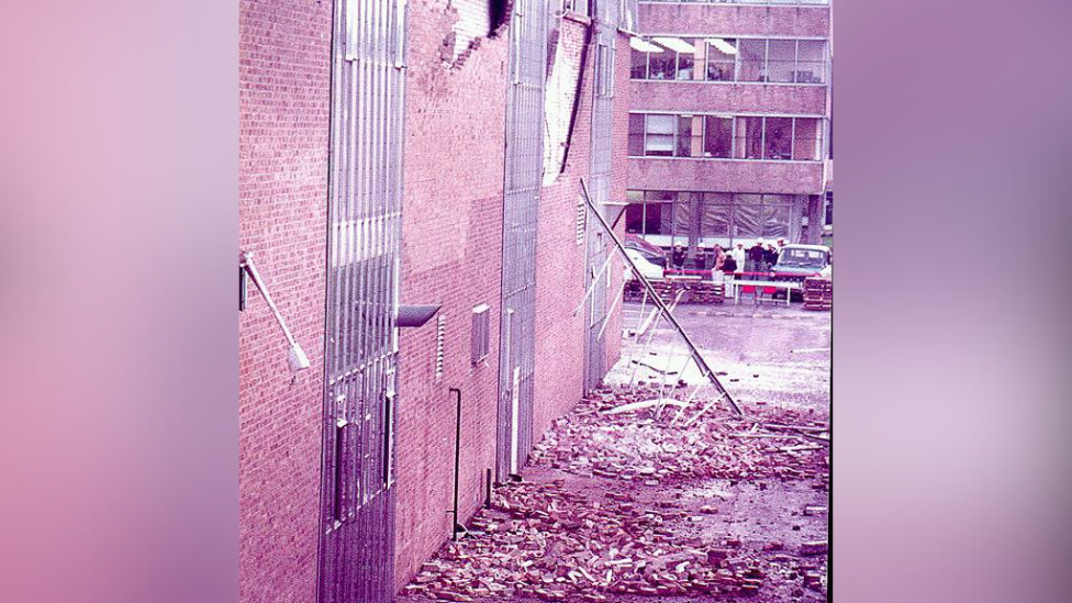 An archive image of the building at GF with lots of debris on the floor, and lots of holes in the building.