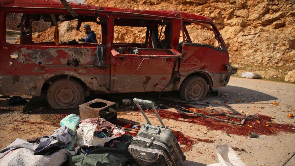 People inspect a minibus reportedly hit in a Russian air strike in Aleppo province (3 February 2020)