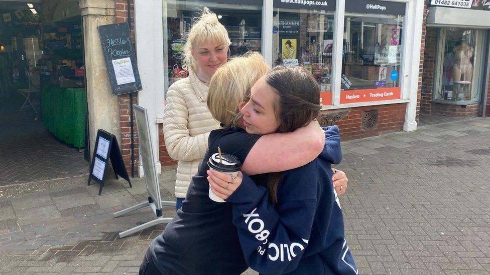 Coffee shop manager Kim Jackson hugs Ukraine refugee Mira Dranyi