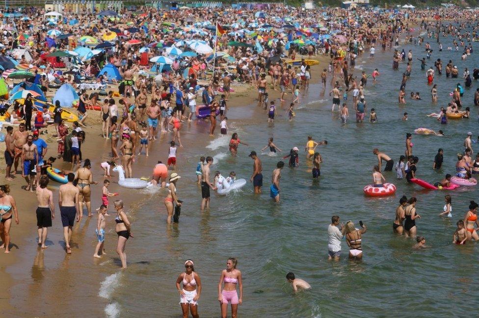 People and children enjoy the hot weather at Bournemouth Beach on June 17