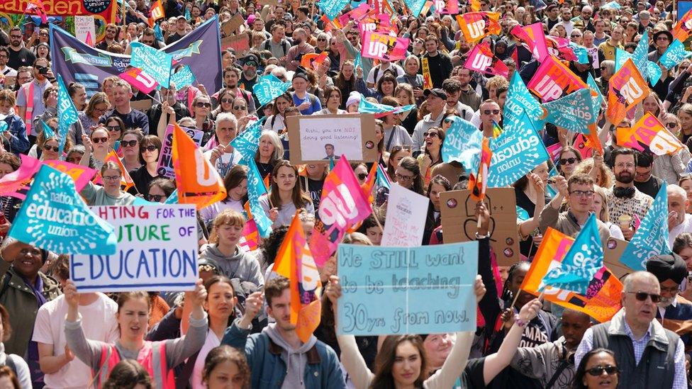 Many teachers striking holding signs