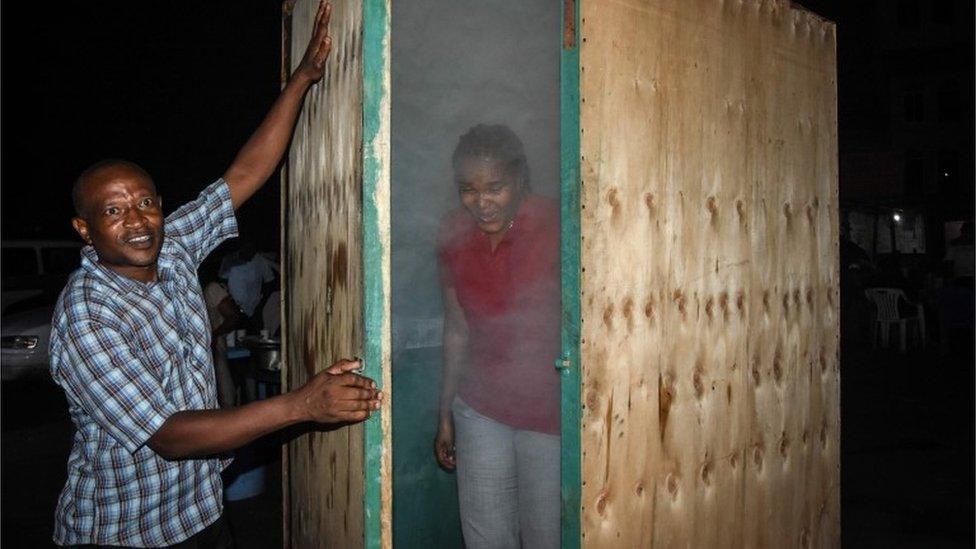 A woman leaves the steam inhalation booth installed by Tanzanian herbalist Msafiri Mjema in Dar es Salaam, Tanzania, on May 22, 2020 after using the treatment as a preventive measure against COVID-19 coronavirus