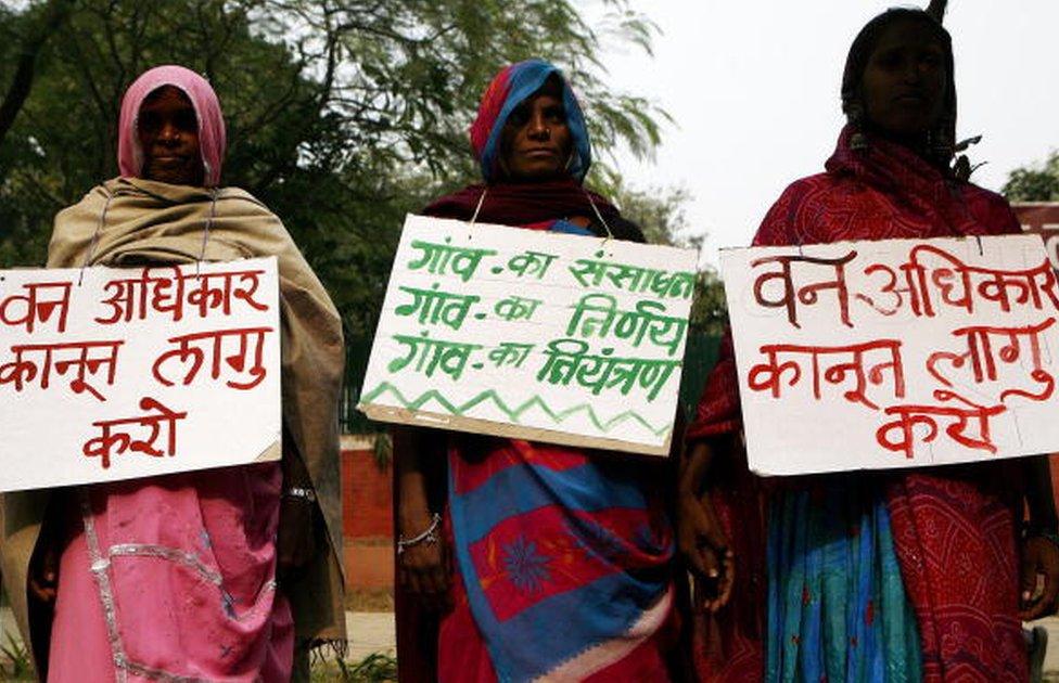 Indian tribal women hold placards as they form a human chain during a protest against the government in New Delhi, 30 November 2007.