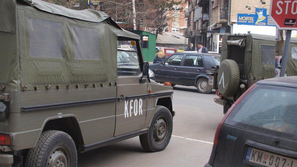 Kfor vehicle passes car with Serbian number-plate in North Mitrovica