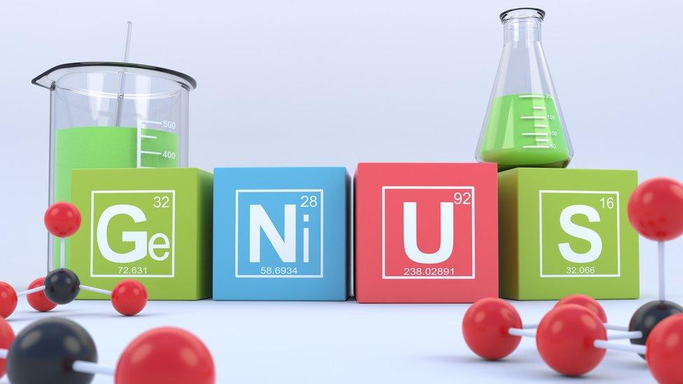 Beakers and blocks spelling out 'genius'