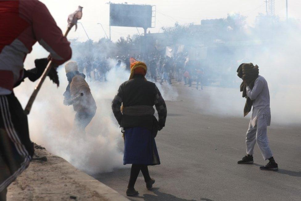 Police use tear gas against farmers during a "parallel parade" on tractors and trolleys amid their ongoing protest against the new agricultural laws, on the outskirts of New Delhi, India, 26 January 2021.