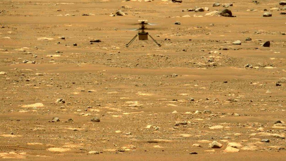 Ingenuity hovering above the Martian terrain