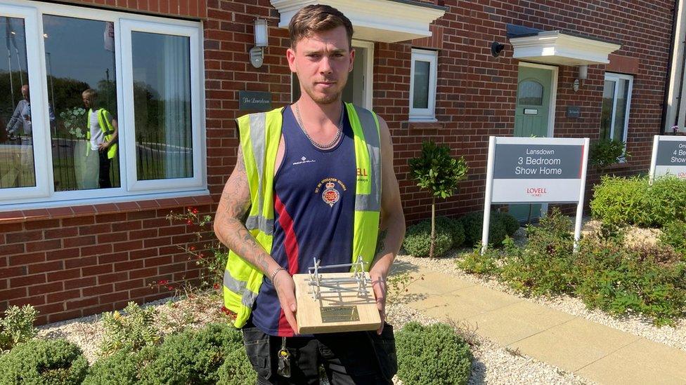 Former Grenadier Guard, Jack Aldis, holds his presentation plaque that includes scaffolding poles in honour of his new career