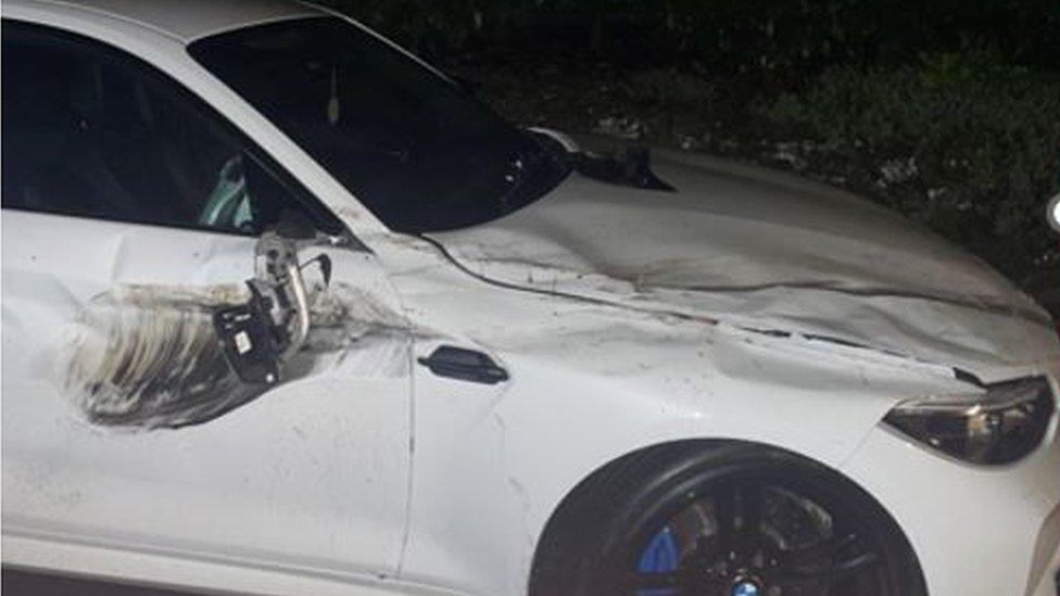 Offside front panel and bonnet of a white car, showing damage from car driving over it