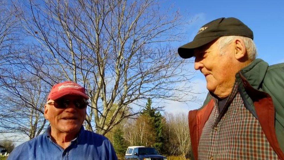 A cemetery maintenance worker listens as Mr Kickham explains why he is doing the work himself